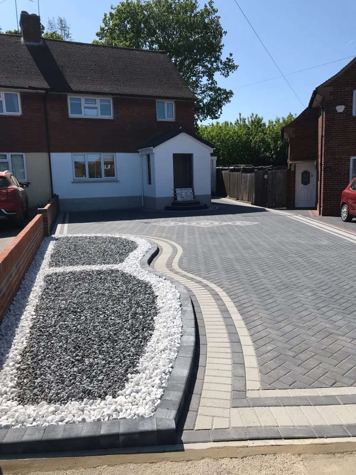 Block paved driveway with charcoal blocks and red border