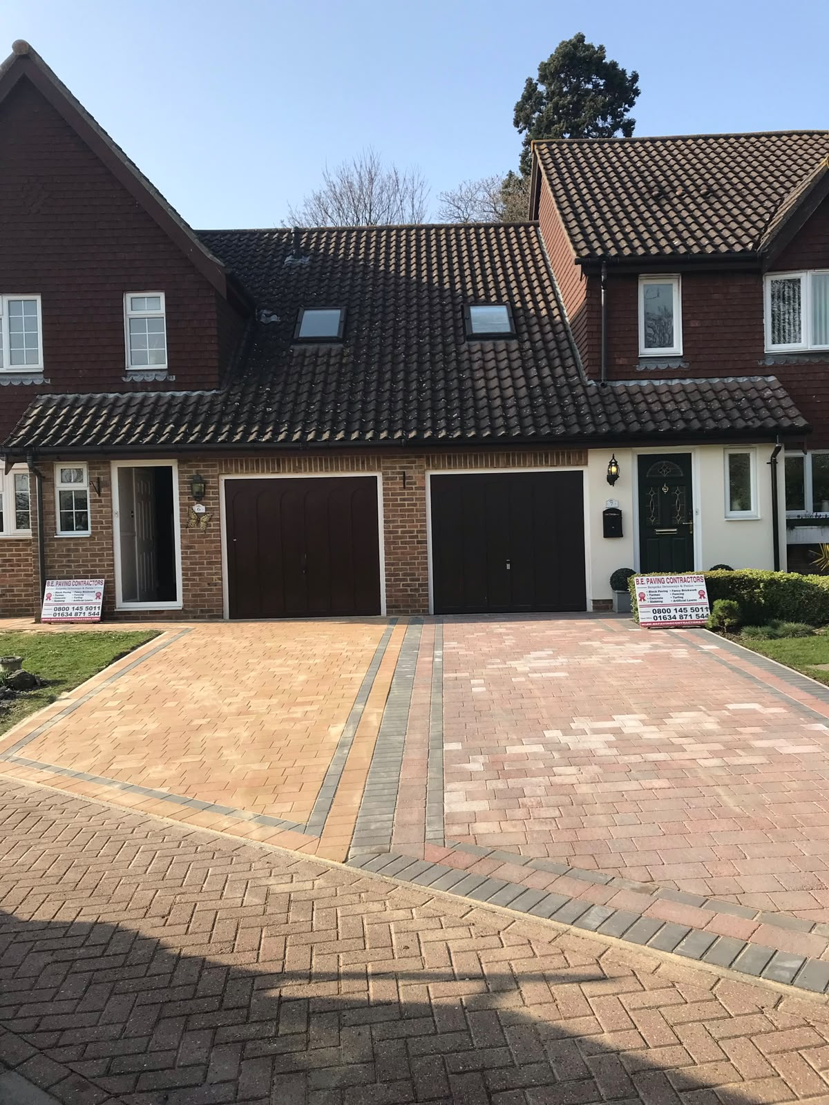 Large block paved driveway in mixed warm tones outside a double garage